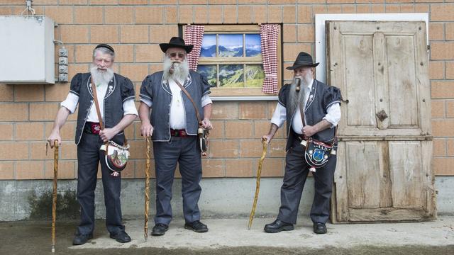 Trois armaillis posent avant le défile du grand cortège de la Poya à Estavannens (FR) en 2013. [Keystone - Jean-Christophe Bott]