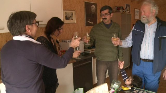Pascal Corminboeuf et sa femme trinquant avec la famille kurde. [RTS]