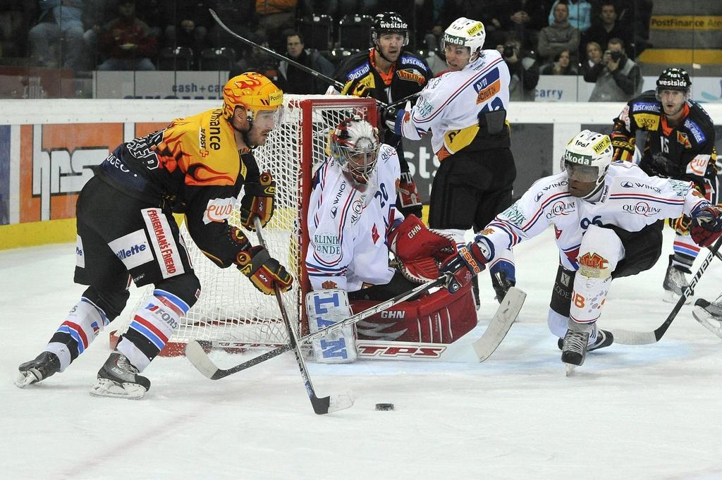 Travis Roche (à g.), en duel avec Reto Berra dans les buts biennois et Clarence Kparghai. [KEYSTONE - PETER SCHNEIDER]