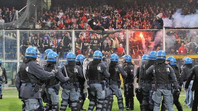 Des policiers casqués massés au pied de la tribune où étaient installés les 1600 supporters serbes. Ceux-ci devront quitter le stade sous escorte.