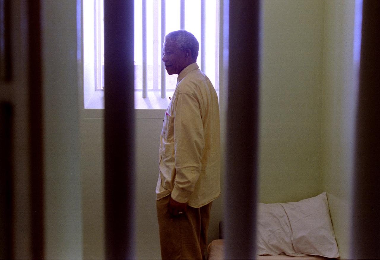 1994 - De retour à Robben Island. Mandela revient en visite dans la cellule où il a passé la majorité de ses 27 ans d'emprisonnement. Dans un extrait de lettre il décrit "une monotonie frustrante" avec, chaque jour, les "mêmes visages, mêmes dialogues, mêmes odeurs, mêmes murs s'élevant vers le ciel". [© Patrick de Noirmont / Reuters]