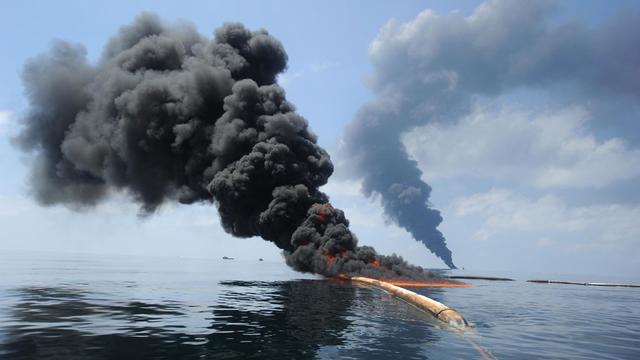 Le feu a été mis à la nappe de pétrole en plusieurs endroits. [Photo US Navy]