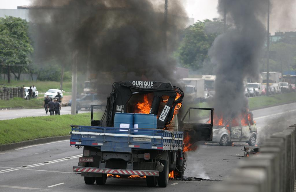 Les trafiquants ont mis le feu à des véhicules et des pneus pour faciliter leur fuite. [KEYSTONE - AP Photo/Alexandre Vieira, Agencia O Dia]