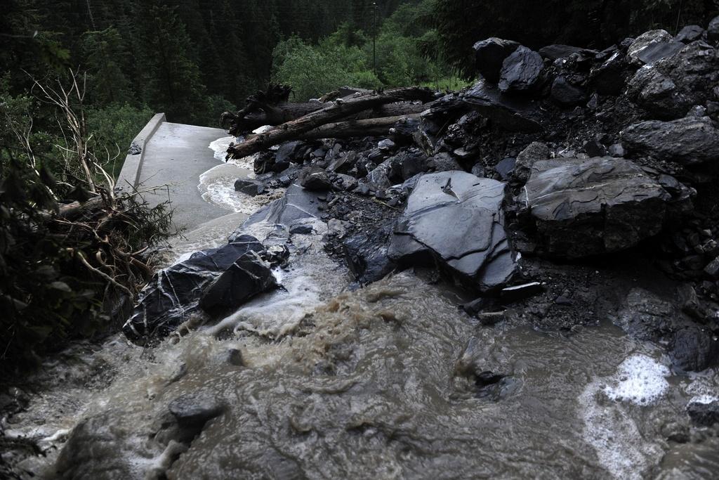 A Château d'Oex, la rivière l'Eau froide a débordé et une masse de gravats a emporté une voiture. [KEYSTONE - JEAN-CHRISTOPHE BOTT]