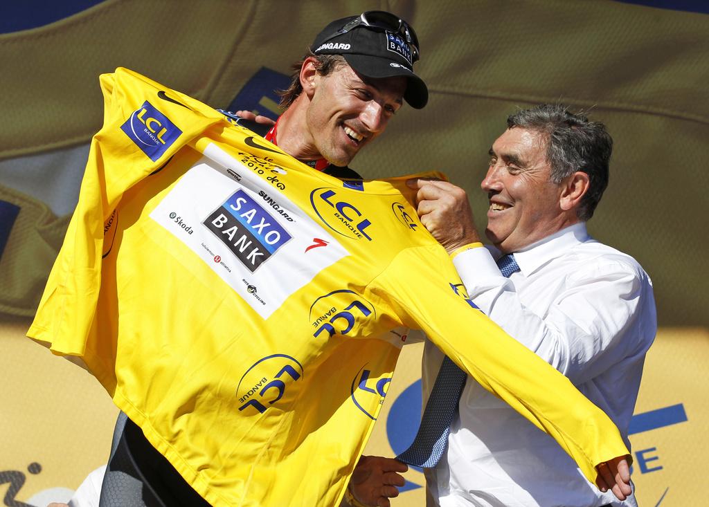 Eddy Merckx enfile le maillot jaune sur le dos de Cancellara. Ou quand deux grands champions montent sur le même podium. [KEYSTONE - Bas Czerwinski]