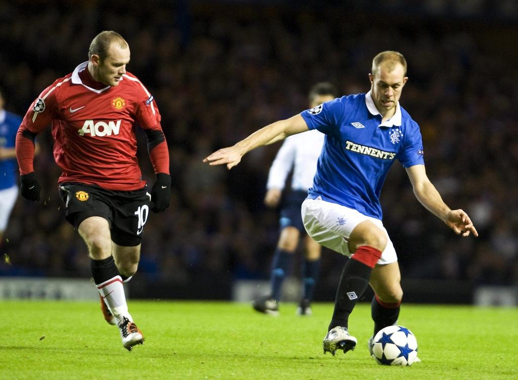 Malgré le retour de Wayne Rooney (en rouge), Manchester a peiné à Glasgow. [KEYSTONE - Brian Stewart.]