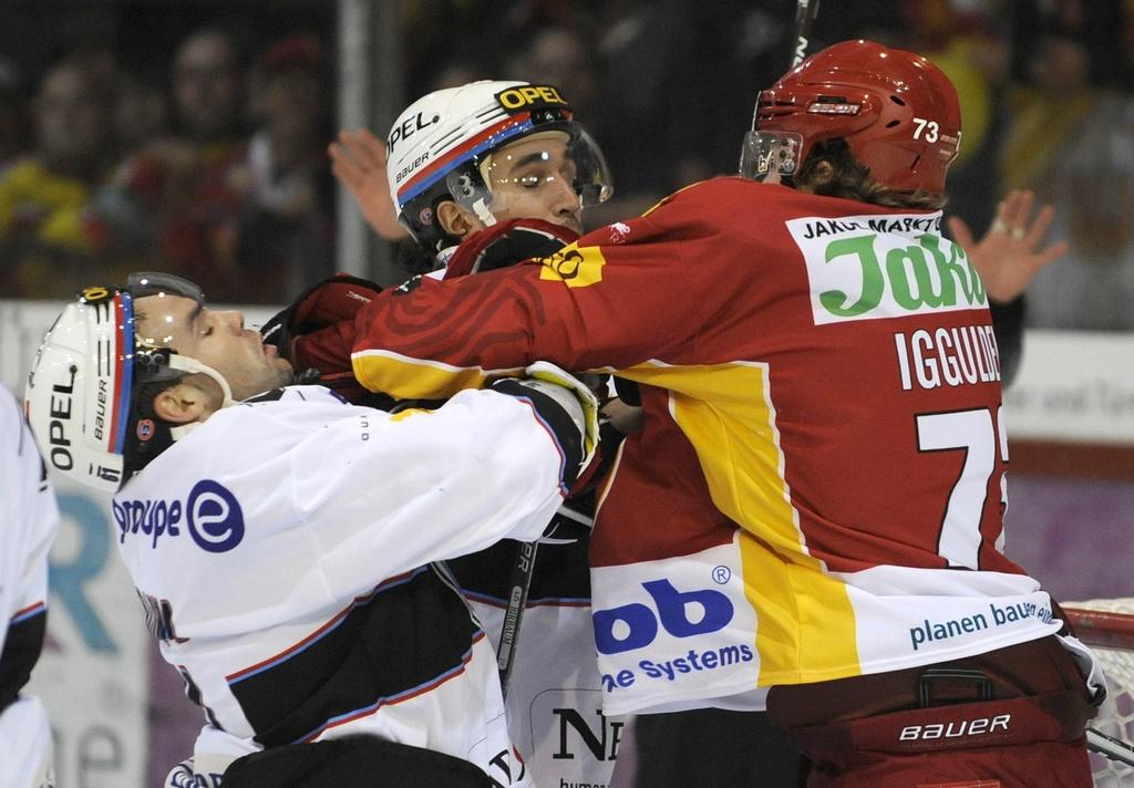 Mike Iggulden et Alain Birbaum (FR-Gottéron) encerclent Lukas Gerber. Tendu! [KEYSTONE - Marcel Bieri]