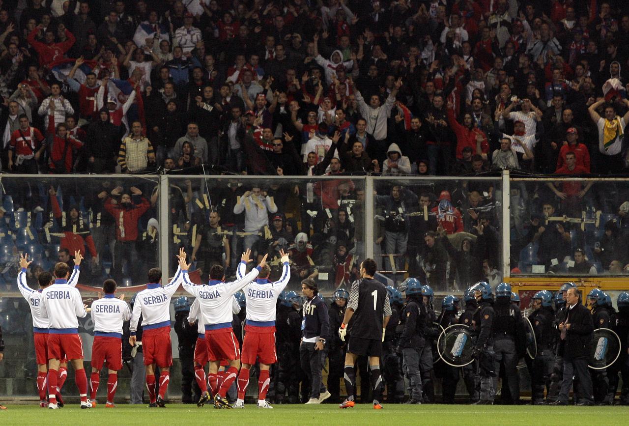 Malgré l'intervention des joueurs, les supporters serbes n'ont pas cessé de lancer des fumigènes. [REUTERS - � Alessandro Garofalo / Reuters]