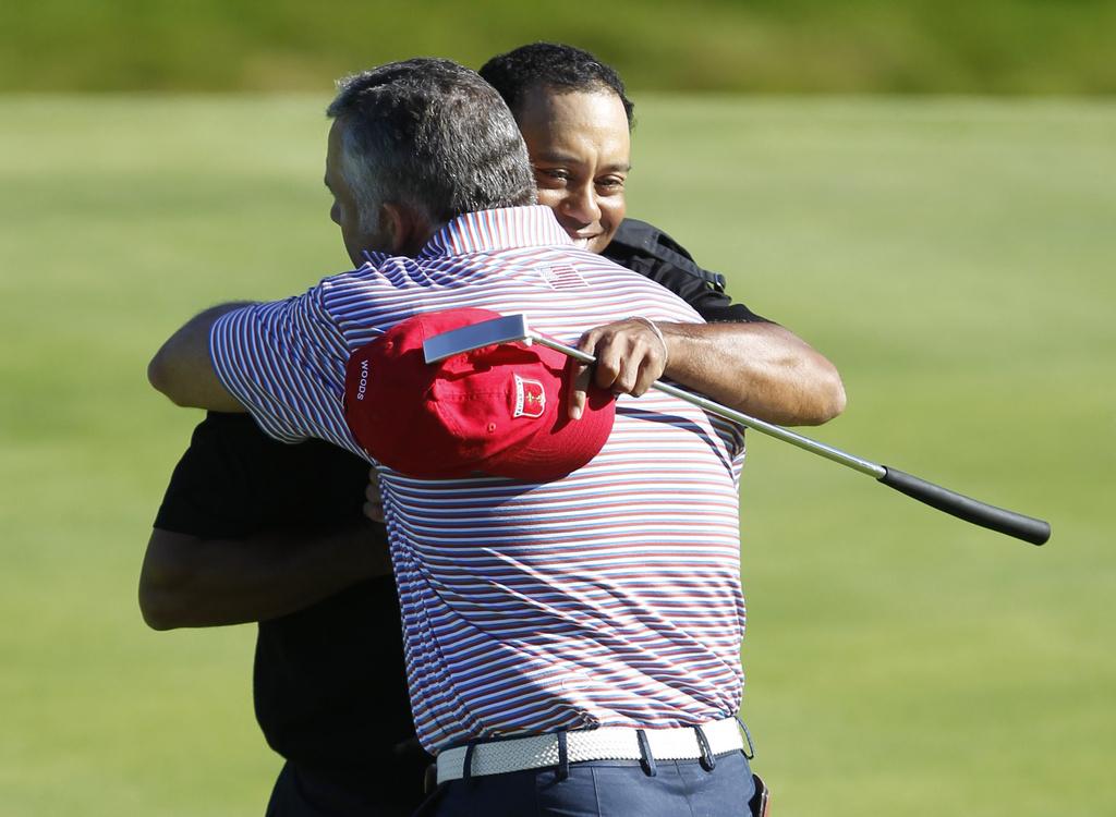 Vainqueur de son duel, Tiger Woods tombe dans les bras de son caddie. Mais les USA s'inclineront. [KEYSTONE - Peter Morrison]