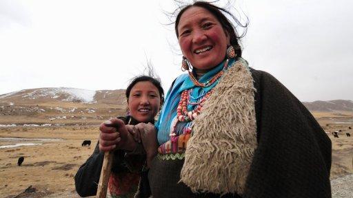 Une mère tibétaine et sa fille accompagne leur troupeau de yaks sur la route vers Lhassa, le 9 mars 2009