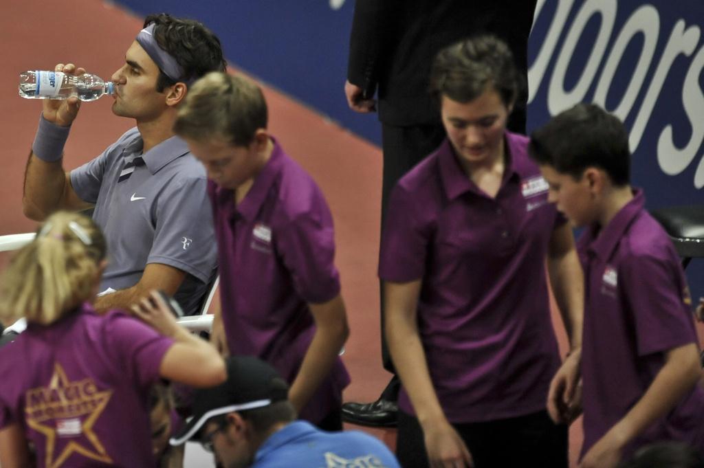 Les ramasseurs de balle à côté de leur idole. Federer a, dans sa jeunesse, exercé cette même tâche. [KEYSTONE - MATTHIAS WAECKERLIN]