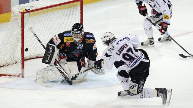 Lauper glisse le puck entre les jambes de Bührer: 3-1 pour Gottéron. [Peter Klaunzer]