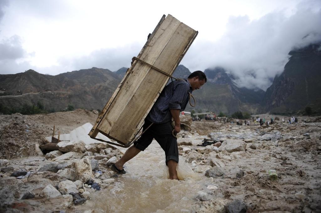 Dans la province ravagée du Gansu, un villageois transporte un cercueil.