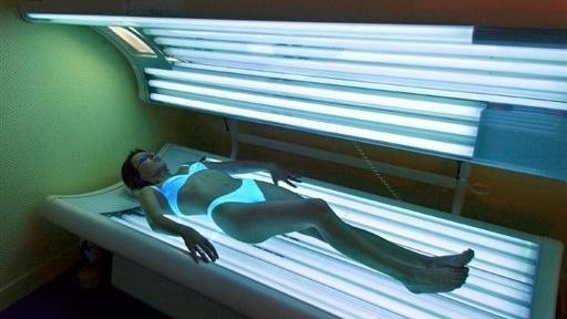 Une jeune femme est allongée sous des lampes d'UV, le 11 mai 2004 dans un institut de beauté de Caen