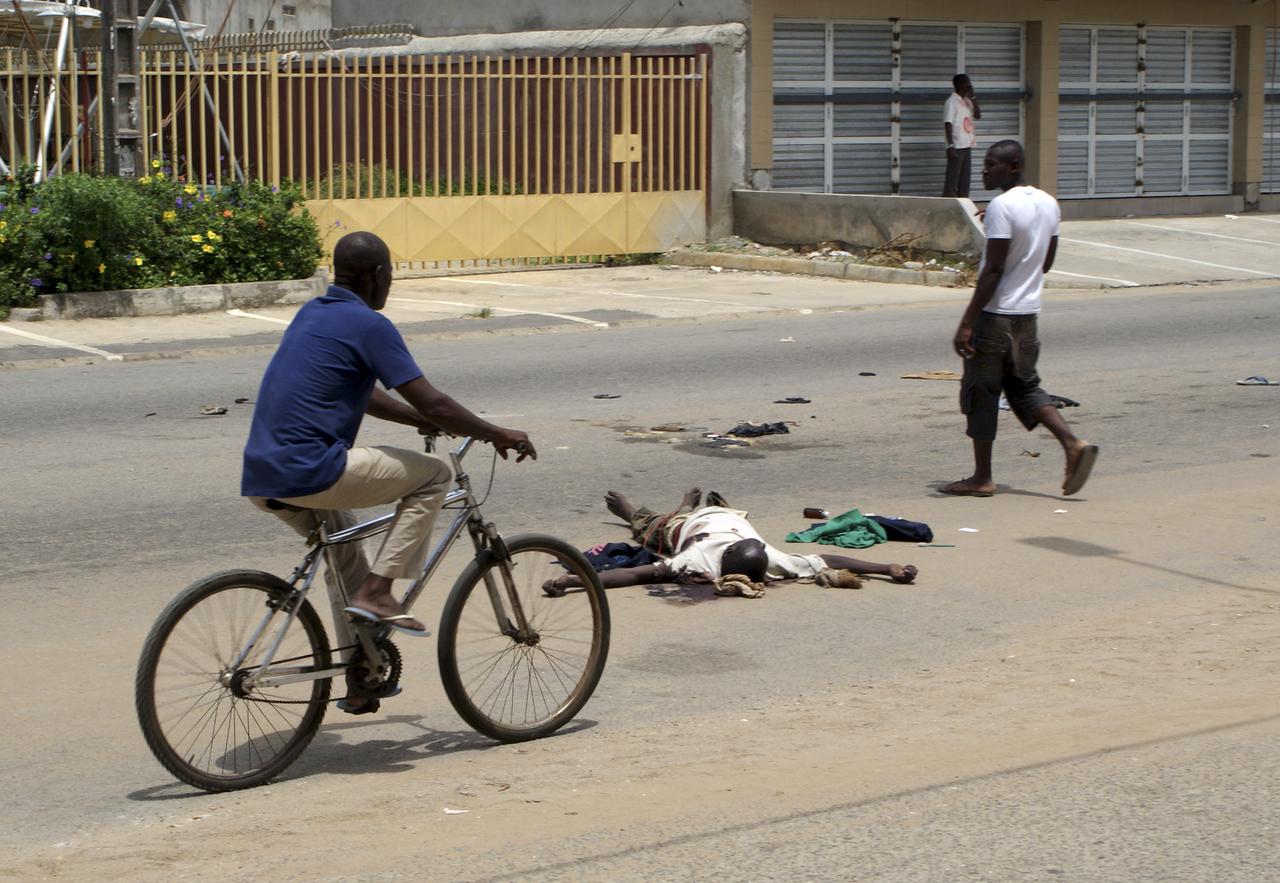 Illustration des combats à Abidjan: des dépouilles mortelles jonchent le sol au milieu des passants. [Reuters - Thierry Gouegnon]