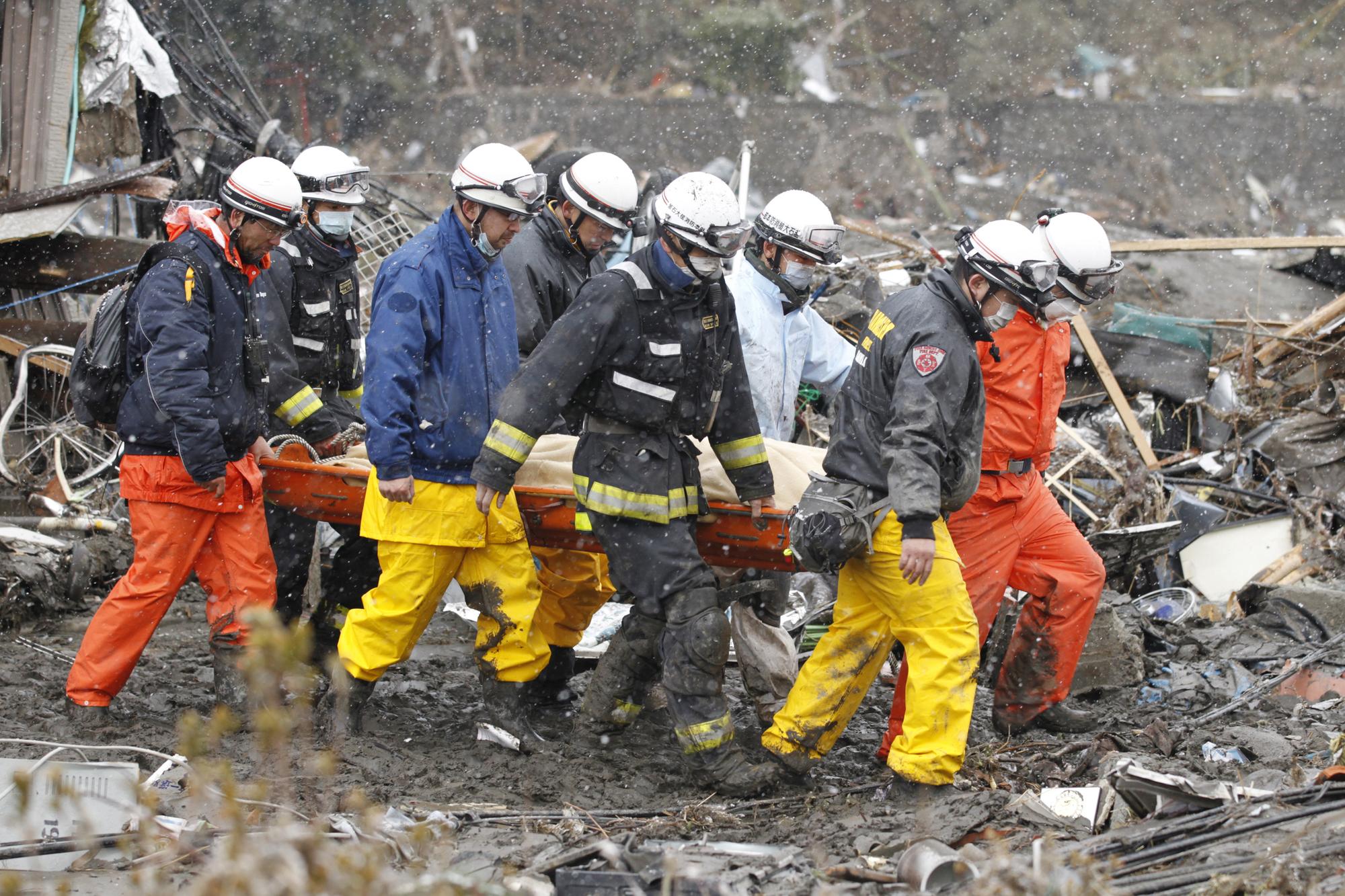 Des secouristes japonais évacuent la dépouille d'une victime du séisme à Kamaishi. [REUTERS - Lee Jae-Won]
