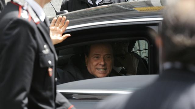 Le premier ministre italien Silvio Berlusconi a salué les photographes en quittant lundi le palais de justice de Milan, dont il considère les juges comme le "cancer de la démocratie". [Alessandro Garofalo]