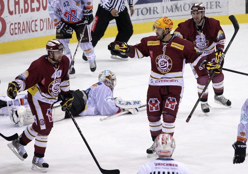 Geneve-Servette's Goran Bezina, centre, celebrates between his teammates Daniel Rubin, left, and Rico Fata, of Canada, right, after scoring the 2:0, during the game of National League A (NLA) Swiss Championship between Geneve-Servette HC and EHC Biel-Bienne, at the ice stadium Les Vernets, in Geneva, Switzerland, Tuesday, October 18, 2011. (KEYSTONE/Salvatore Di Nolfi) [Salvatore Di Nolfi]