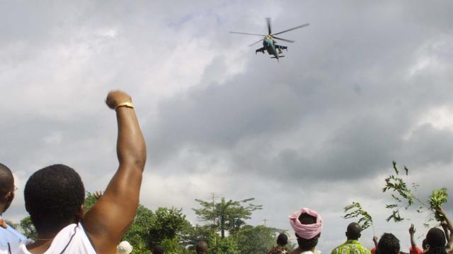 Un hélicoptère d'attaque Mi-24 survole un village ivoirien lors d'accrochages entre troupes françaises et partisans de Gbagbo en 2004. [Kampbell]