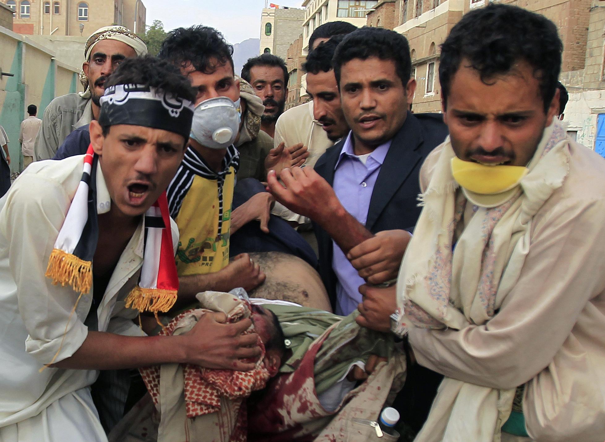 Ces protestataires anti-gouvernement portent l'un d'entre eux, blessé, à Sanaa. [REUTERS - Khaled Abdullah]