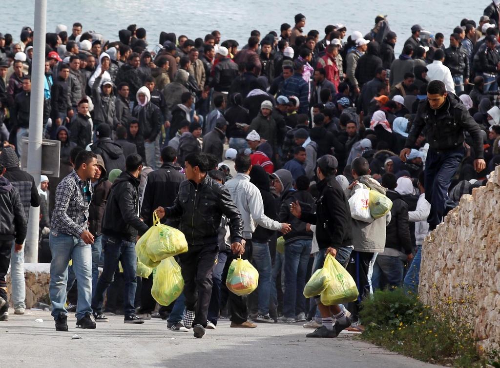 Des immigrés attendent sur les quais de Lampedusa. [KEYSTONE - VENEZIA FILIPPO]