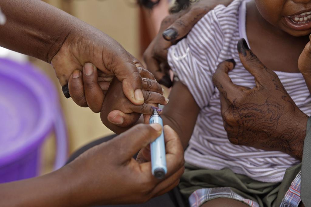 Un enfant est marqué après sa vaccination dans la ville de Liboi au Kenya. [KEYSTONE - Schalk van Zuydam]