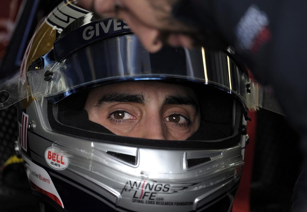 Assis dans sa Toro Rosso, Sébastien Buemi semble dubitatif. [KEYSTONE - MARTIN PHILBEY]