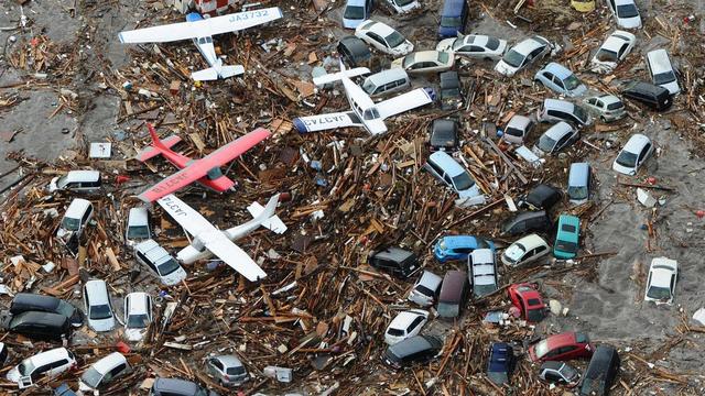 Des voitures et des avions légers ont été emportés par la vague ayant ravagé l'aéroport de Sendai, première ville touchée par le tsunami. [KEYSTONE - Kyodo]