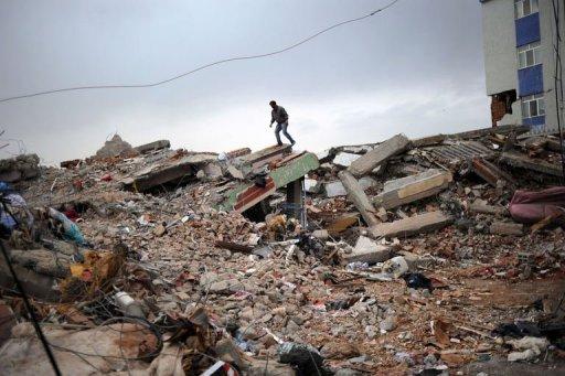 Un homme sur les décombre d'un immeuble détruit par un tremblement de terre à Ercis, en Turquie, le 26 octobre 2011