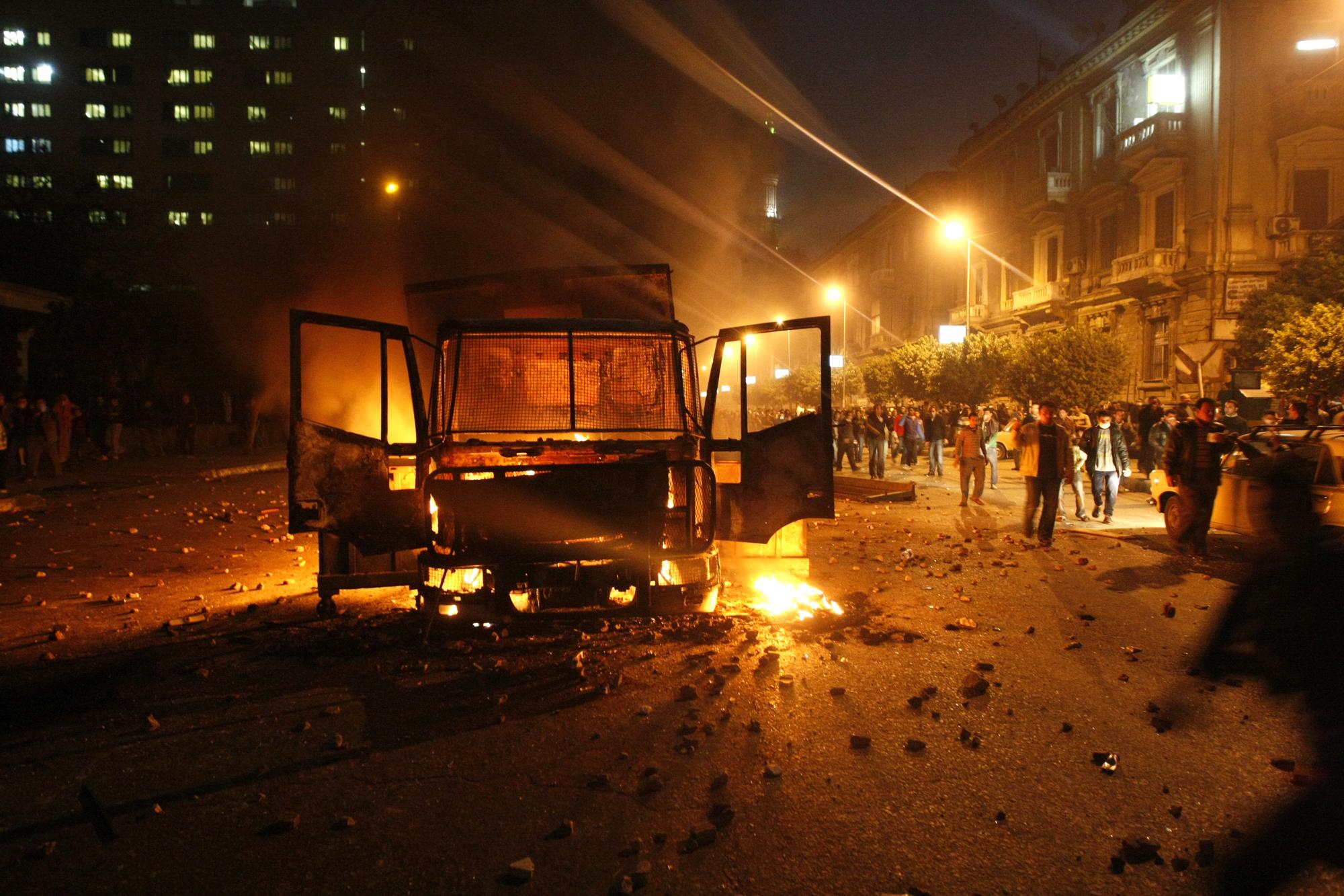 Bravant le couvre-feu, des centaines d'Egyptiens sont sortis dans les rues vendredi soir, brûlant de nouveau des véhicules. [AFP - MOHAMMED ABED]