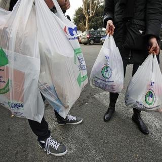 Les consommateurs italiens utilisant des sacs biodégradables après l'interdiction de sacs plastiques en Italie entrée en vigueur le 3 janvier 2010. [Keystone - Alessandro Di Meo]