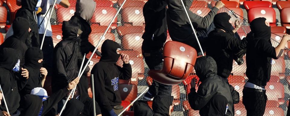 Des hooligans du FC Zurich cagoulés et "armés" de piquets servant plutôt à faire flotter les drapeaux de leur équipe. [Alessandro Della Bella]