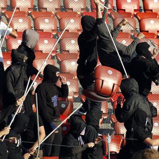 Des hooligans du FC Zurich cagoulés et "armés" de piquets servant plutôt à faire flotter les drapeaux de leur équipe. [Alessandro Della Bella]