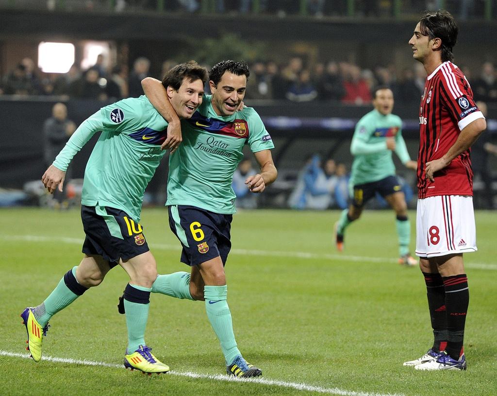 epa03013308 FC Barcelona's midfielder Xavi Hernandez (C) and teammate Argentinian striker Lionel Messi (L) celebrate the opening goal during a UEFA Champions League Group H soccer matchbetween AC Milan FC Barcelona at the Giuseppe Meazza stadium, Milan, Italy, 23 November 2011. EPA/DANIEL DAL ZENNARO [KEYSTONE - Daniel Dal Zennaro]