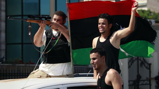 Ces jeunes combattants rebelles célèbrent lors de leur entrée dans le district de Qarqarsh, à Tripoli. [Bob Strong]