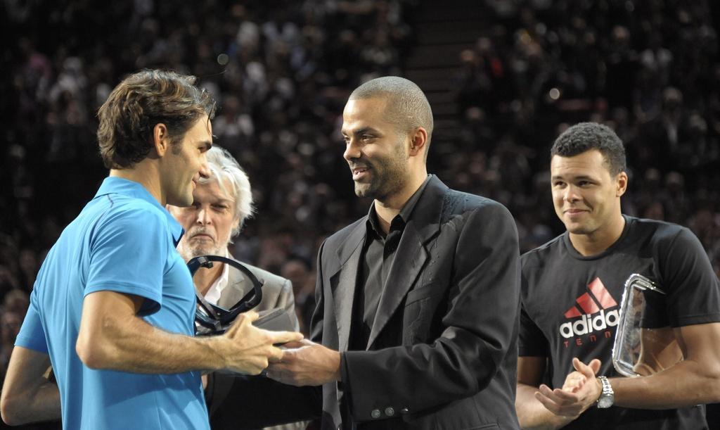 La star du basket Tony Parker remet le trophée à "RF" sous le regard amusé de Tsonga. [KEYSTONE - Horacio Villalobos]