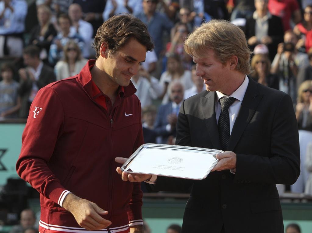 Jim Courier remet à Roger Federer le plateau d'argent réservé au finaliste malheureux. [KEYSTONE - Kerim Otken]