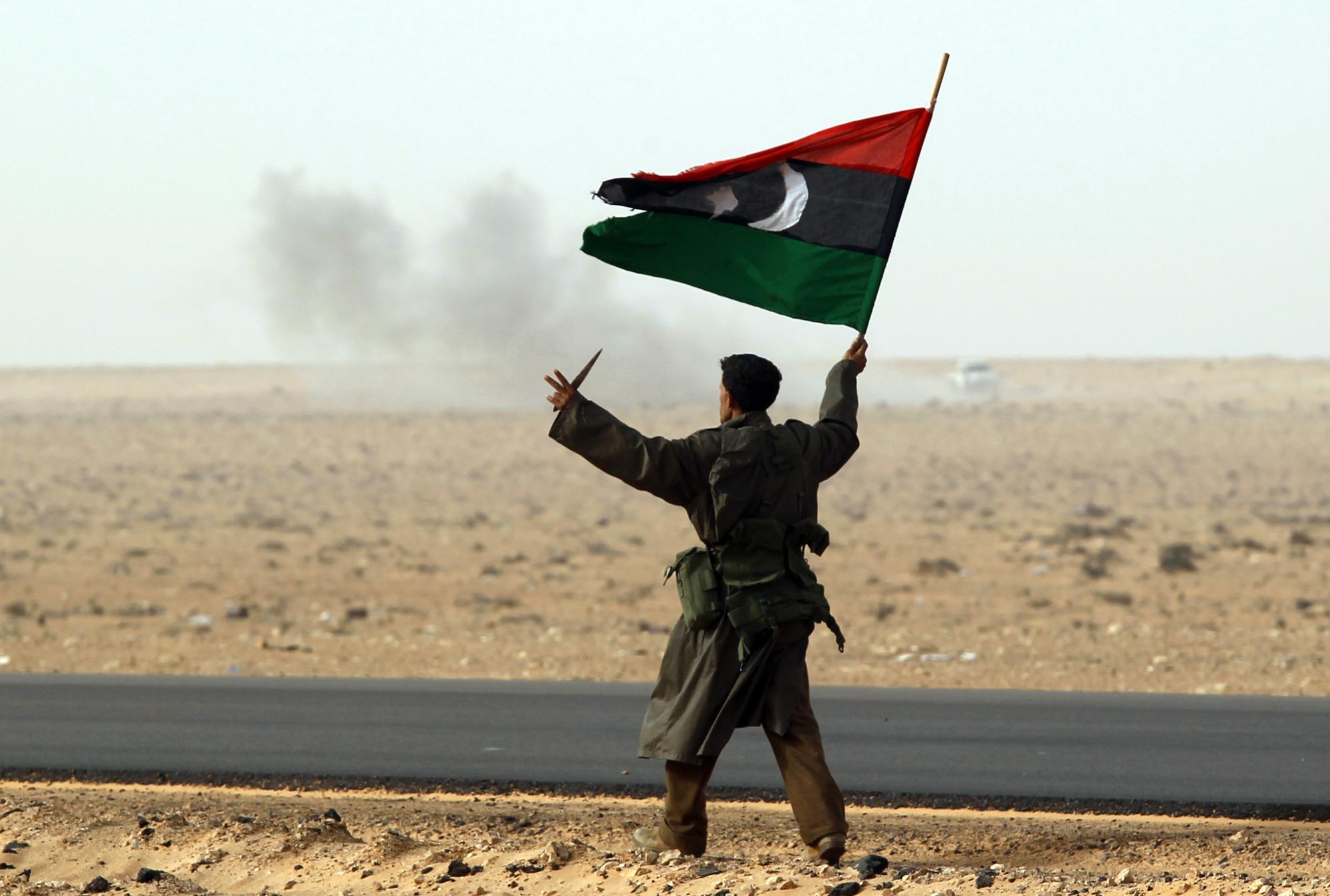 Copy of Un rebelle brandit le drapeau libyen près du champ de bataille de Ras Lanuf. [Goran Tomasevic]