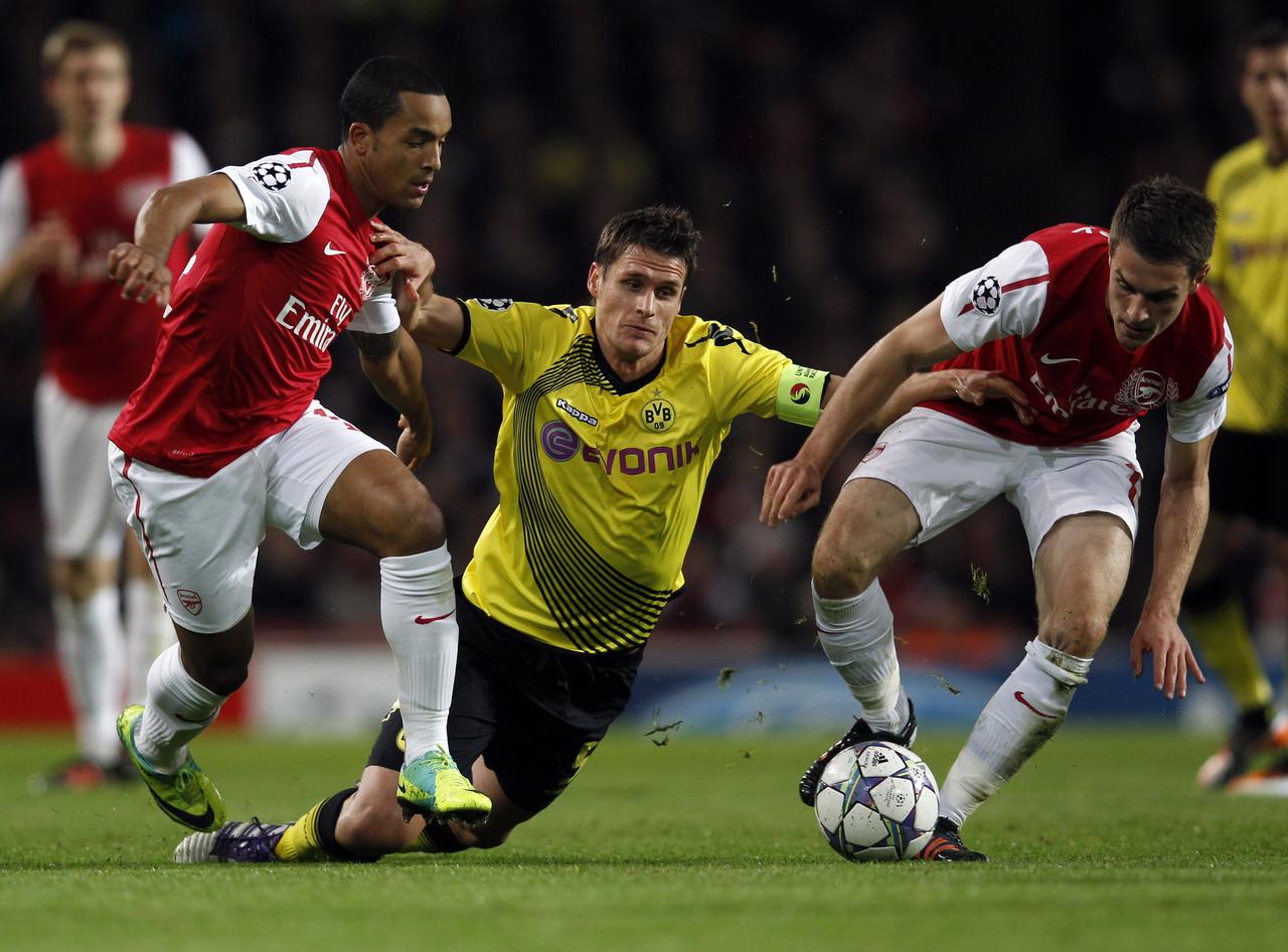 Arsenal's Theo Walcott (L) and Aaron Ramsey (R) tackle Borussia Dortmund's Sebastian Kehl during their Group F Champions League soccer match at the Emirates stadium in London November 23, 2011. REUTERS/Eddie Keogh (BRITAIN - Tags: SPORT SOCCER TPX IMAGES OF THE DAY) [Eddie Keogh]