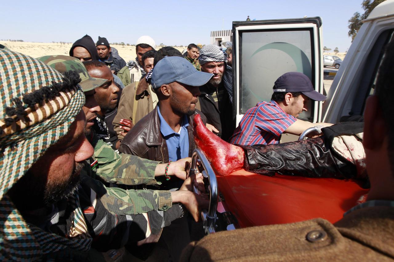 Des rebelles évacuent un blessé du front d'Ajdabiya. [REUTERS - Youssef Boudlal]