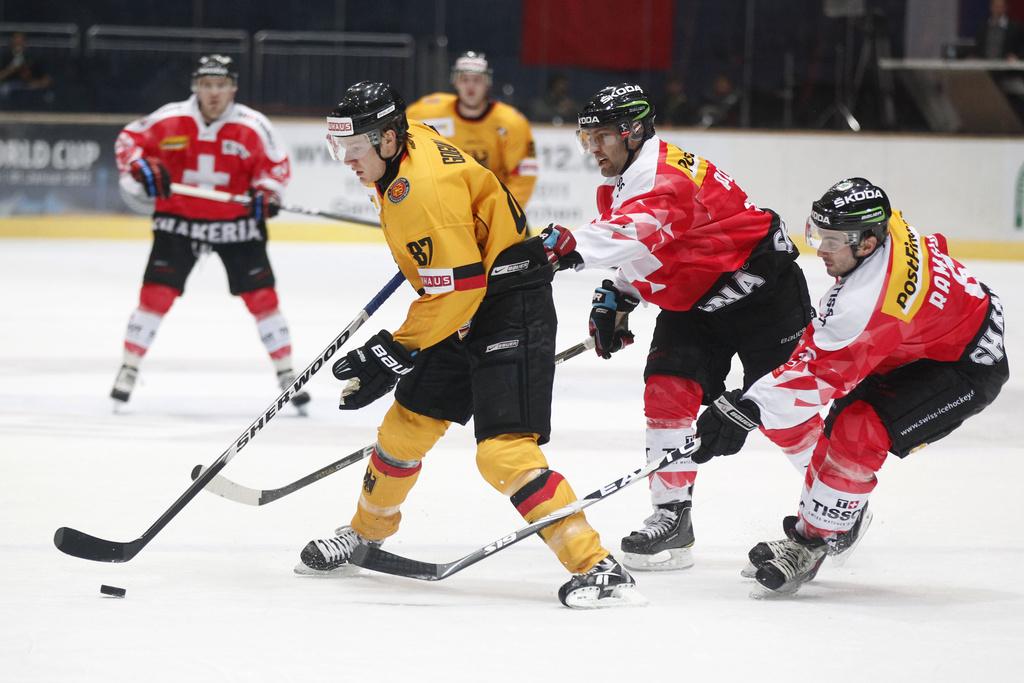 Gogulla, qui se joue ici de Ramholt et Benjamin Plüss, a été un des meilleurs joueurs sur la glace. [KEYSTONE - Sebastian Widmann]