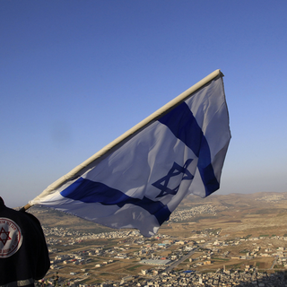 Un citoyen juif israélien lève le drapeau de l'Etat hébreu sur le Mont Gerizim qui surplombe la ville palestinienne de Naplouse [Reuters]