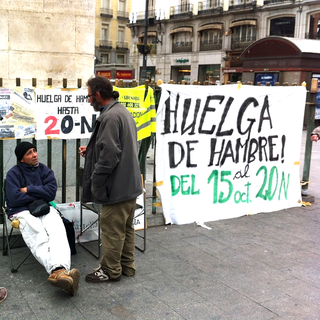 Des chômeurs de longue durée en grève de la faim sur la Puerta del Sol: assis de face, Juan;  debout, celui qui lui parle, Luis. [Valérie Demon]