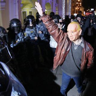 Un manifestant opposé à Vladimir Poutine porte un masque devant les forces de sécurité à Saint-Petersbourg le 8 décembre 2011. [Dmitry Lovetsky]