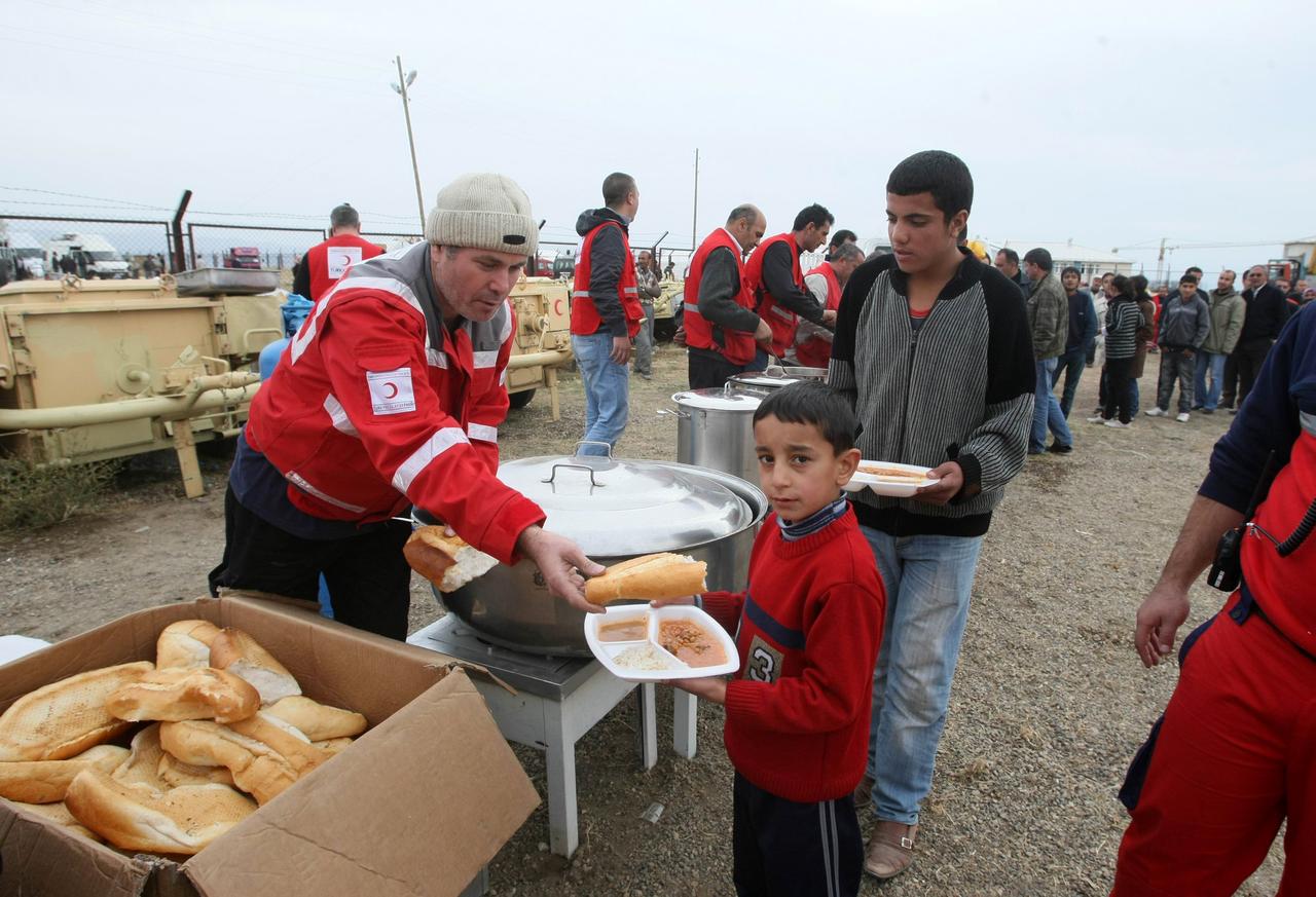 Les rescapés faisaient la queue près de Van, afin de recevoir l'aide humanitaire fournie par le Croissant Rouge turc. [AFP - Adem Altan]