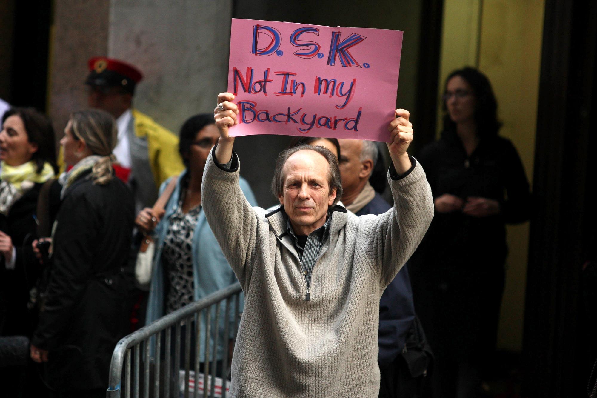 Cet habitant du sud de Manhattan brandit une pancarte où il refuse l'installation de DSK dans son quartier. [AFP - Daniel Barry]
