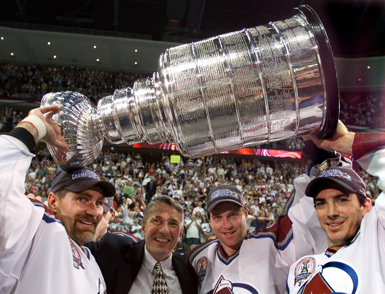 Hartley entouré de ses vedettes des Colorado Avalanche (Bourque, Roy et Sakic, de gauche à droite) en 2001. [REUTERS - Gary Hershorn]