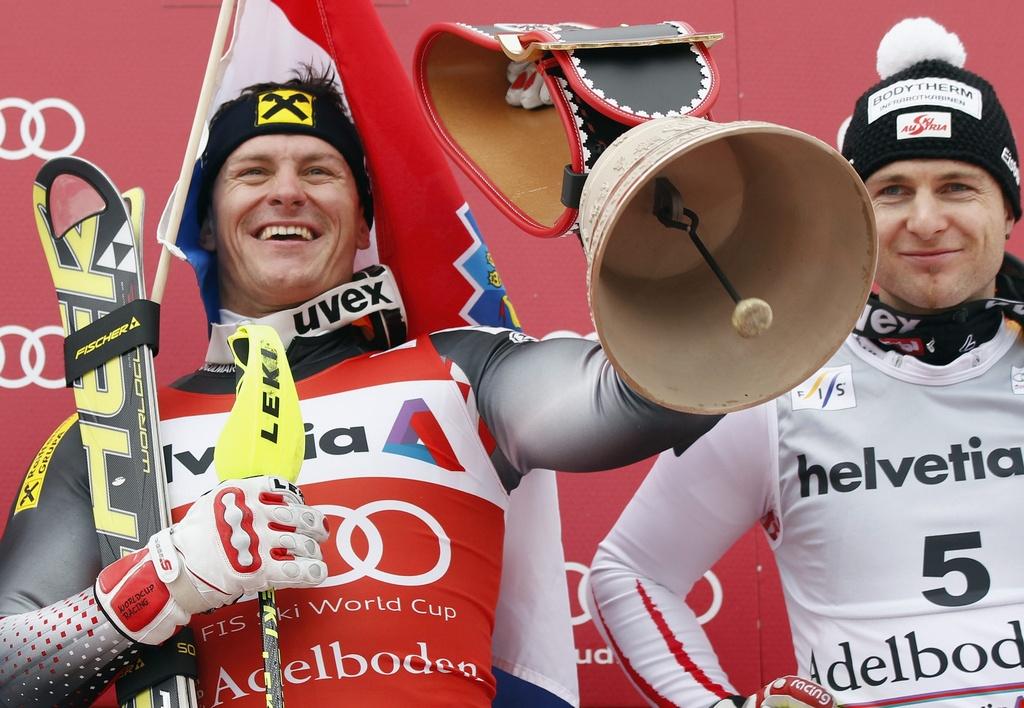 Kostelic, ici avec Herbst, fête son succès avec une cloche de l'Oberland bernois. [KEYSTONE - Peter Klaunzer]