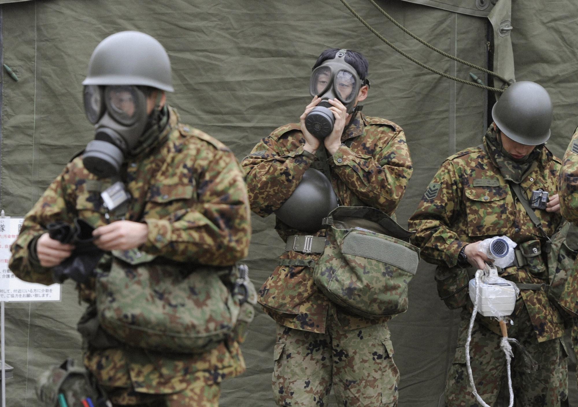 Des soldats japonais s'équipent avant d'intervenir dans les zones contaminées. [REUTERS - Kyodo]