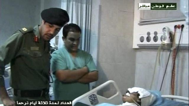 This video image broadcast Wednesday Aug. 10, 2011 by Libyan TV purports to shows Moammar Gadhafi's youngest son Khamis Gadhafi, left, who commands one of the best trained and equipped units in the Libyan military, visiting an injured man in a hospital in Tripoli, Libya on Tuesday Aug. 9, 2011. Libyan state television on Wednesday broadcast images of a man it said was Moammar Gadhafi's youngest son, footage that looks to undercut rebel claims of his death at a time when the opposition is showing signs of strain and disarray six months into its battle with the Libyan leader. (AP Photo/LIbyan TV) LIBYA OUT [KEYSTONE]